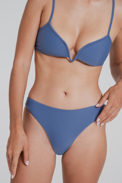 Blue bikini worn by a person on a plain background
