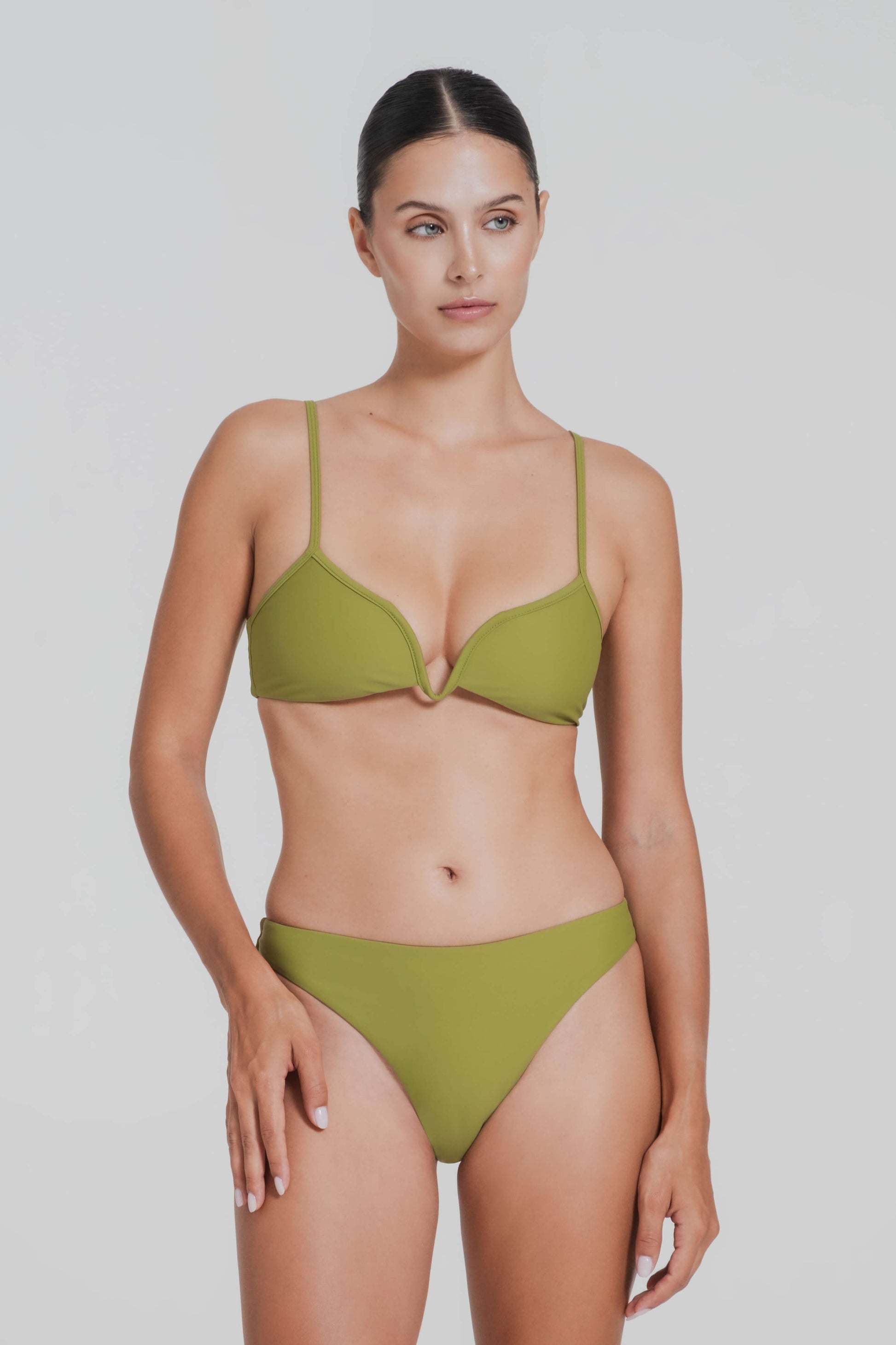 Woman wearing a green bikini against a plain background