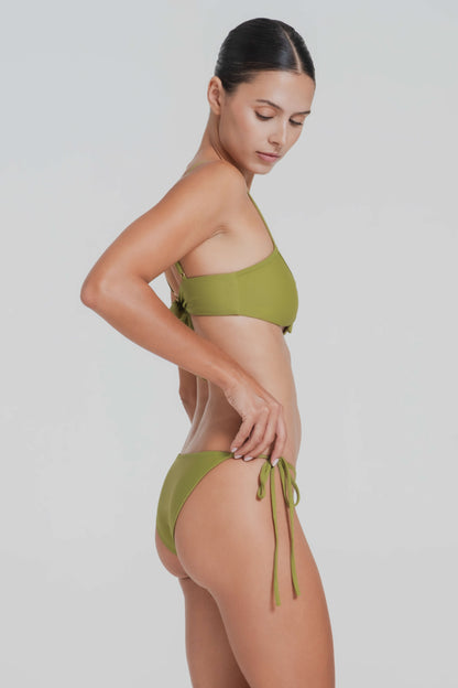 Woman wearing a green bikini against a light gray background