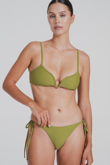 Woman wearing a green bikini against a white background