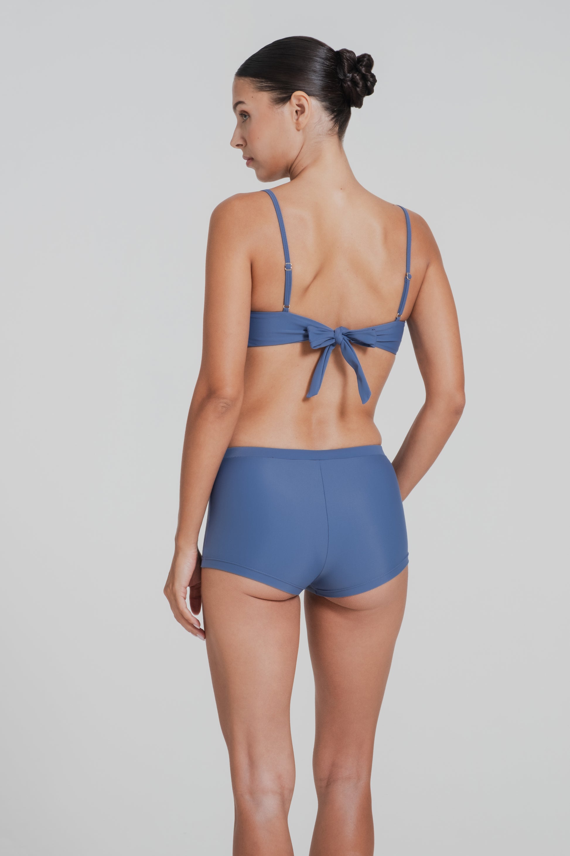 Woman wearing a blue bikini set on a plain background