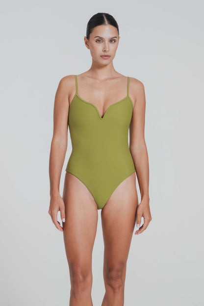 Woman wearing a green swimsuit against a plain background